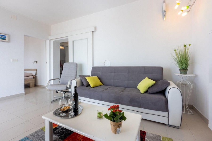 Część dzienna z sofą i otwartym dostępem do sypialni