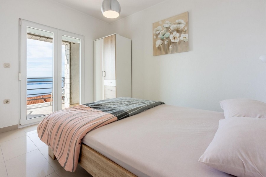 Sypialnia z łóżkiem małżeńskim i dostępem do balkonu