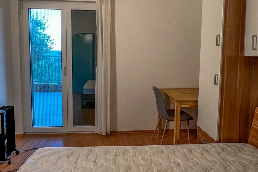 Sypialnia z wyjściem na balkon i biurkiem