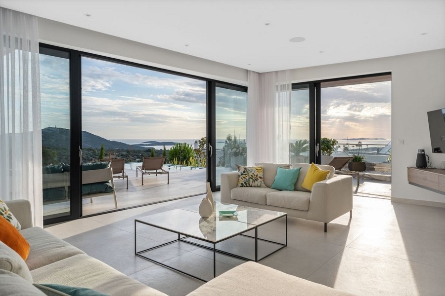 Pokój dzienny z wyjściem na taras i widokiem na nadmorski krajobraz