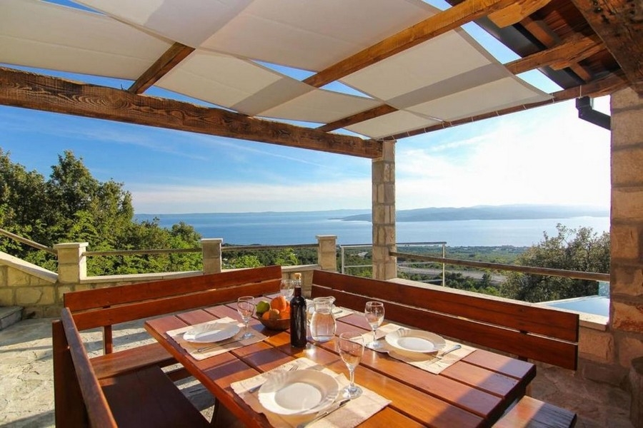 Zadaszony taras z częścią wypoczynkową i widokiem na morze