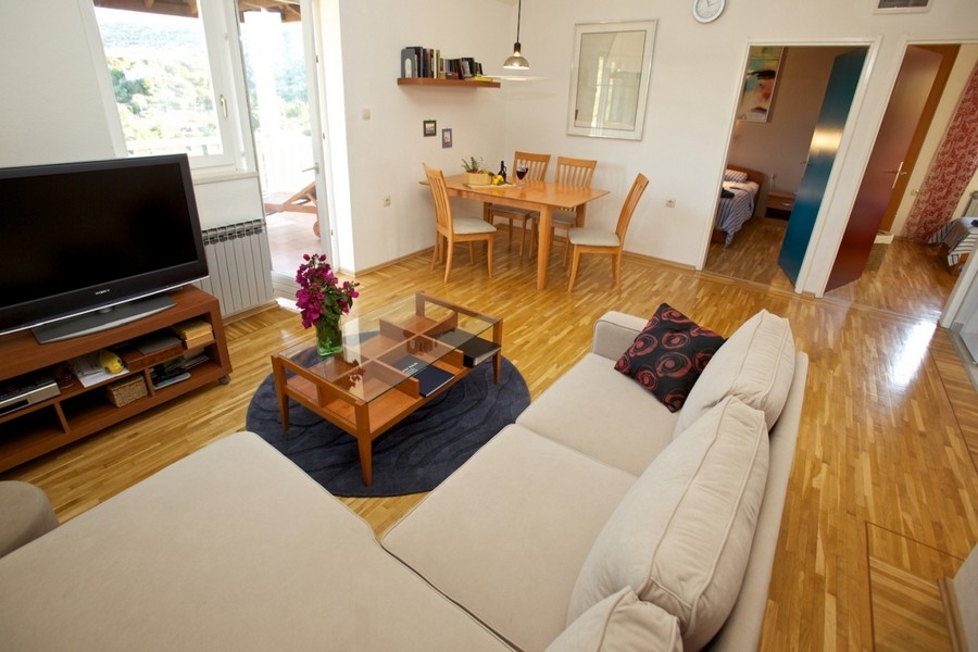 Pokój dzienny z sofą, drewnianą podłogą i jadalnią