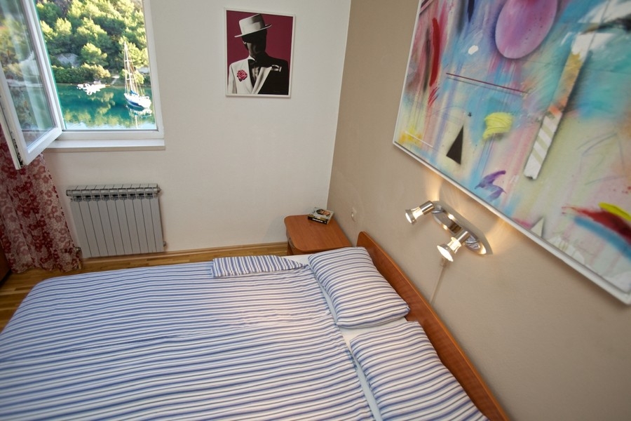 Sypialnia z widokiem na okno na zatokę i żaglówkę