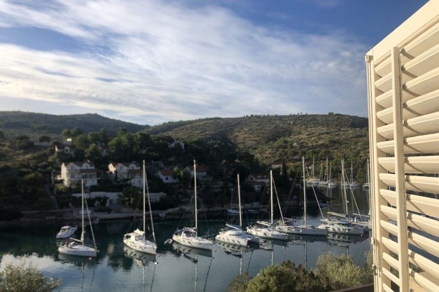 Widok na morze z balkonu z żaglówkami w zatoce