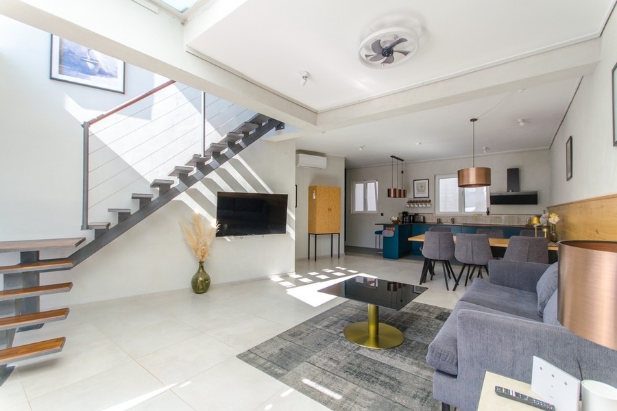 Nowoczesna część dzienna ze schodami i otwartą kuchnią