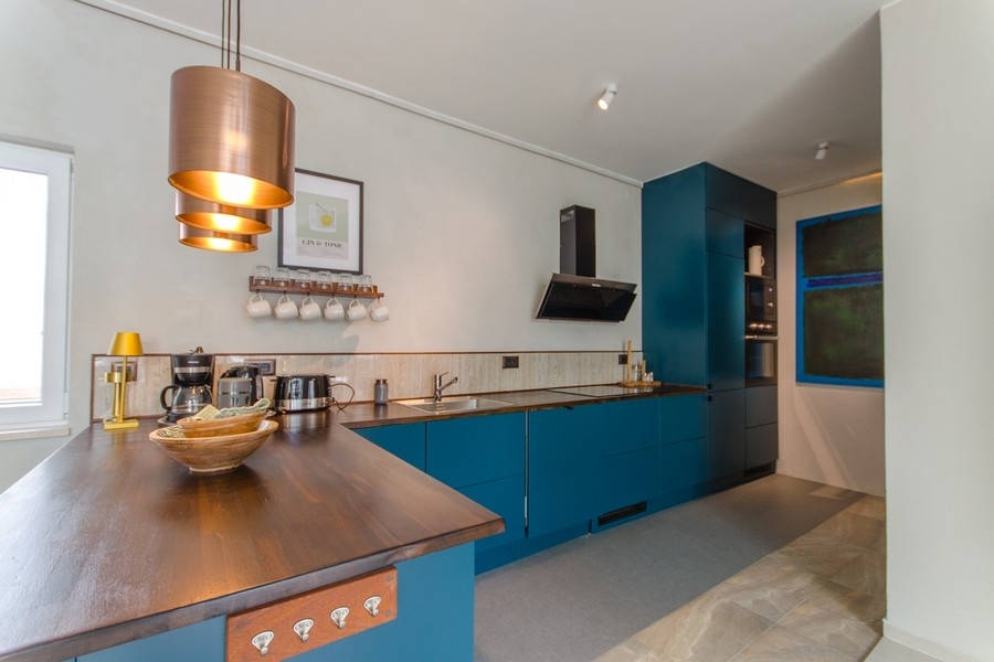 Nowoczesna kuchnia z wyspą kuchenną i drewnianym blatem