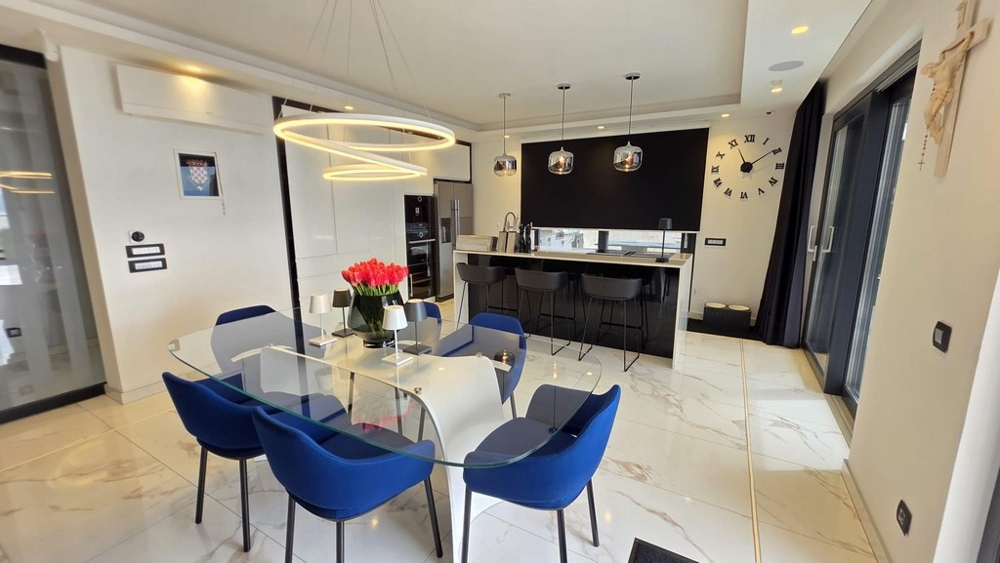 Jadalnia ze szklanym stołem i nowoczesną kuchnią