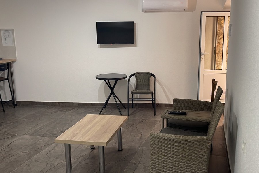 Część dzienna z fotelem i telewizorem w mieszkaniu w Chorwacji