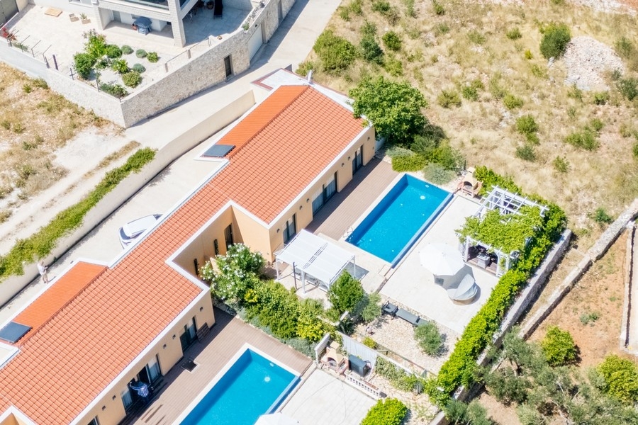 Widok z lotu ptaka na willę z dwoma basenami i tarasami
