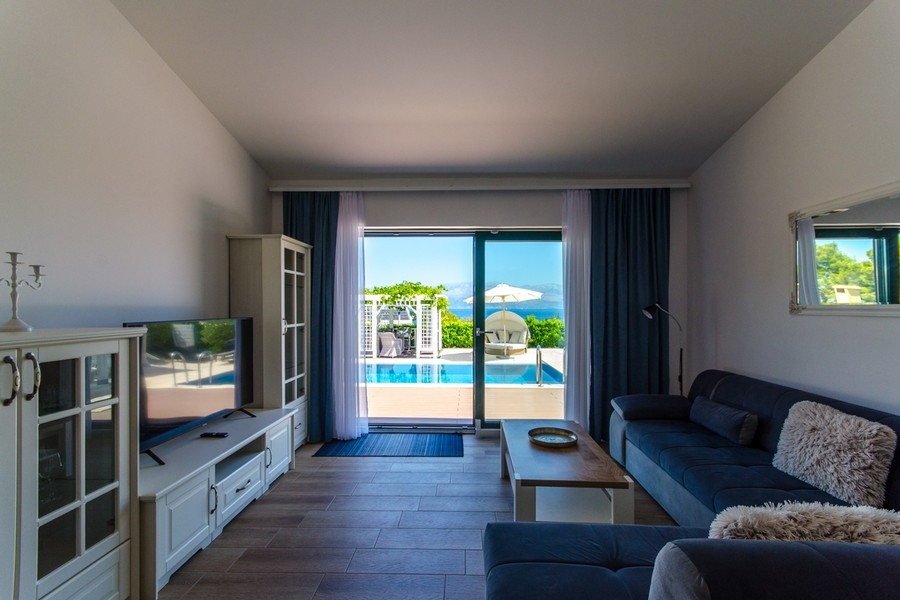 Pokój dzienny z wyjściem na taras i widokiem na basen