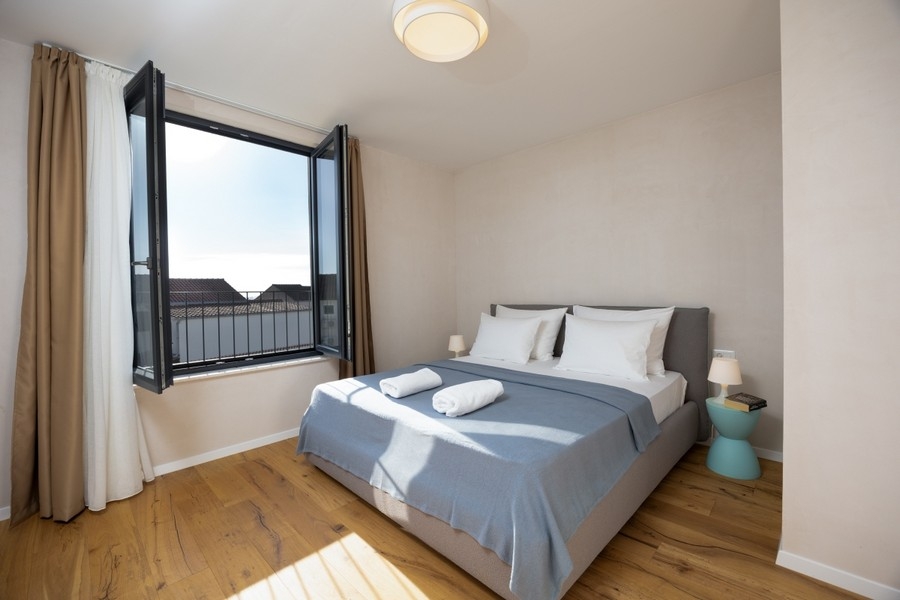 Sypialnia z podwójnym łóżkiem i otwartym oknem