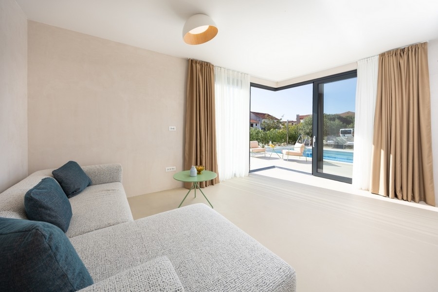 Pokój dzienny z sofą i widokiem na taras i basen