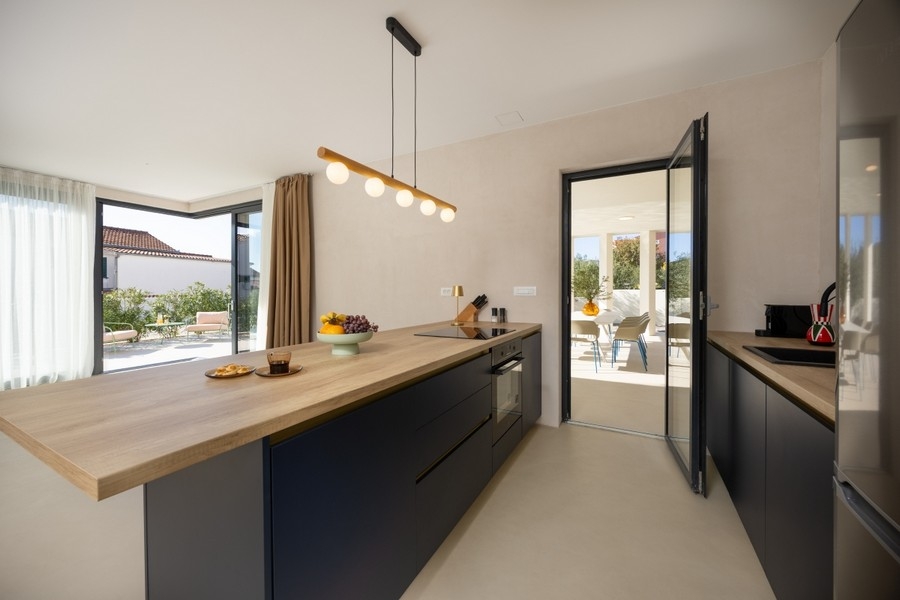 Nowoczesna kuchnia z wyspą kuchenną i wyjściem na taras