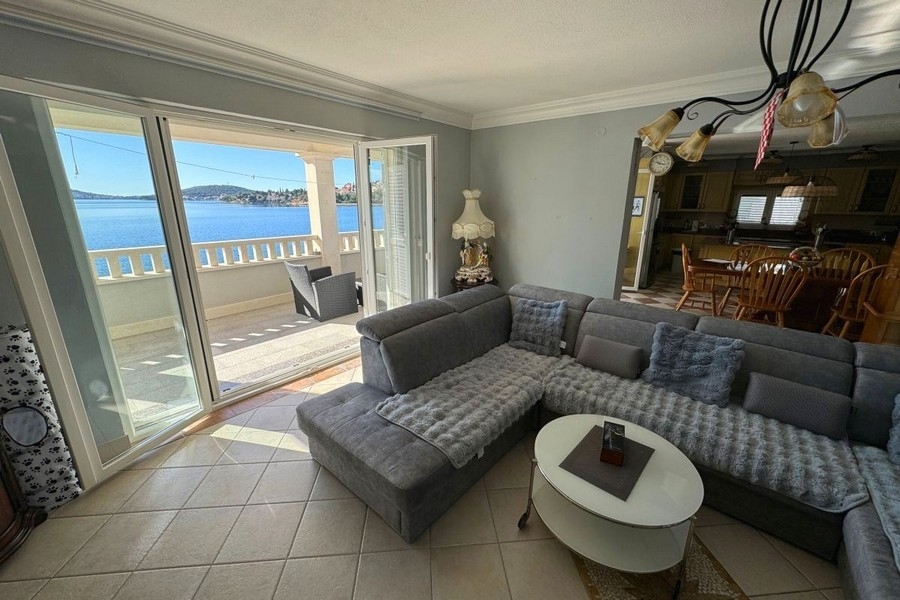 Jasny salon z dużymi oknami i widokiem na morze