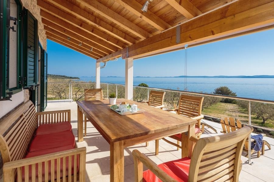 Zadaszony taras ze stołem i widokiem na morze