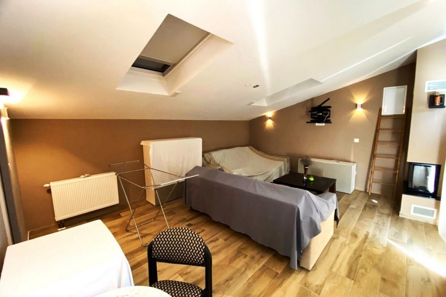 Część dzienna na poddaszu z kominkiem i świetlikiem