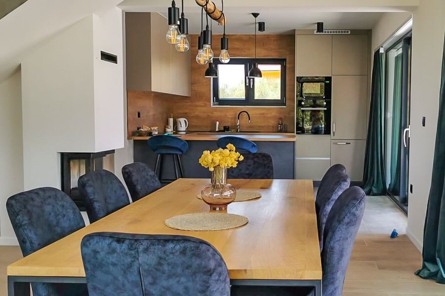 Otwarta część dzienna z kuchnią i kominkiem w nowoczesnej willi