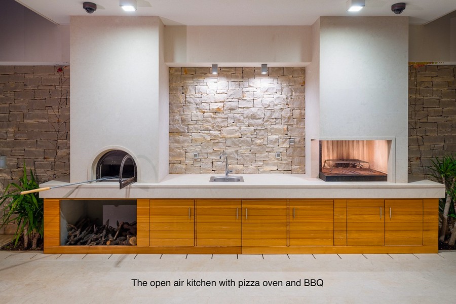 Kuchnia na świeżym powietrzu z piecem do pizzy, grillem i powierzchnią roboczą