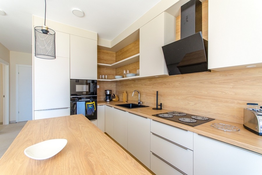 Nowoczesna kuchnia z zabudową AGD i drewnianym blatem