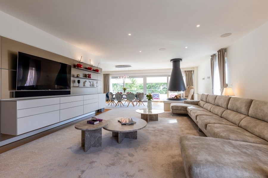 Przestronny salon z nowoczesnymi meblami i kominkiem