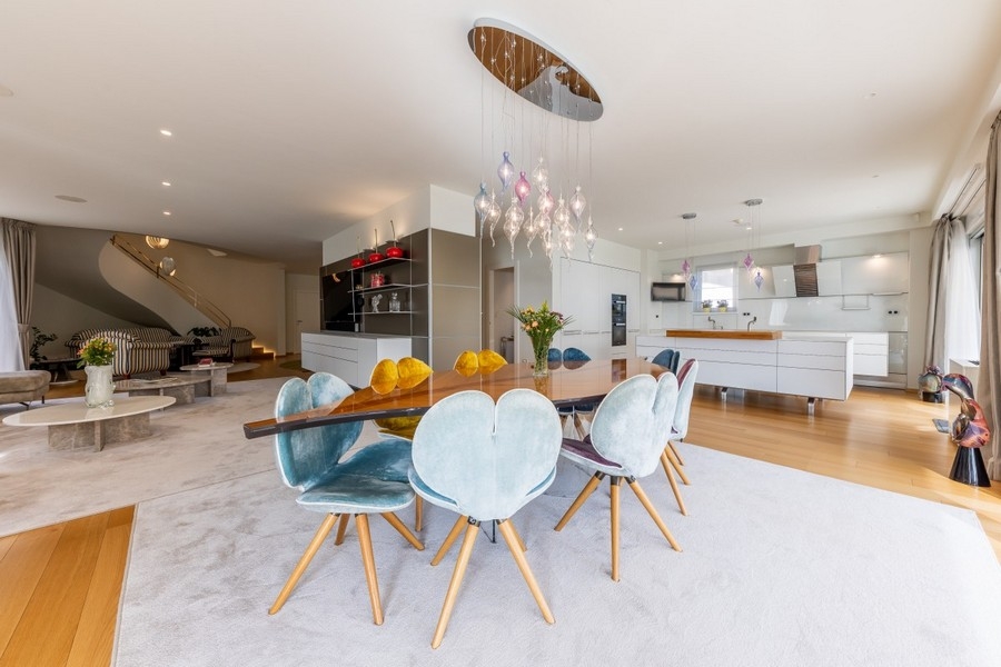 Otwarta jadalnia z designerskim oświetleniem i nowoczesną kuchnią