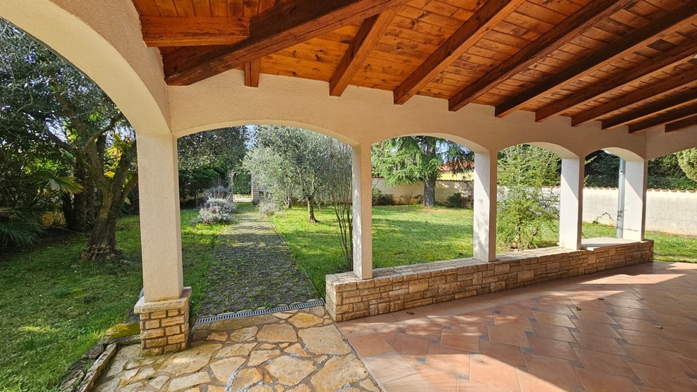 Zadaszony taras z częścią wypoczynkową i widokiem na ogród