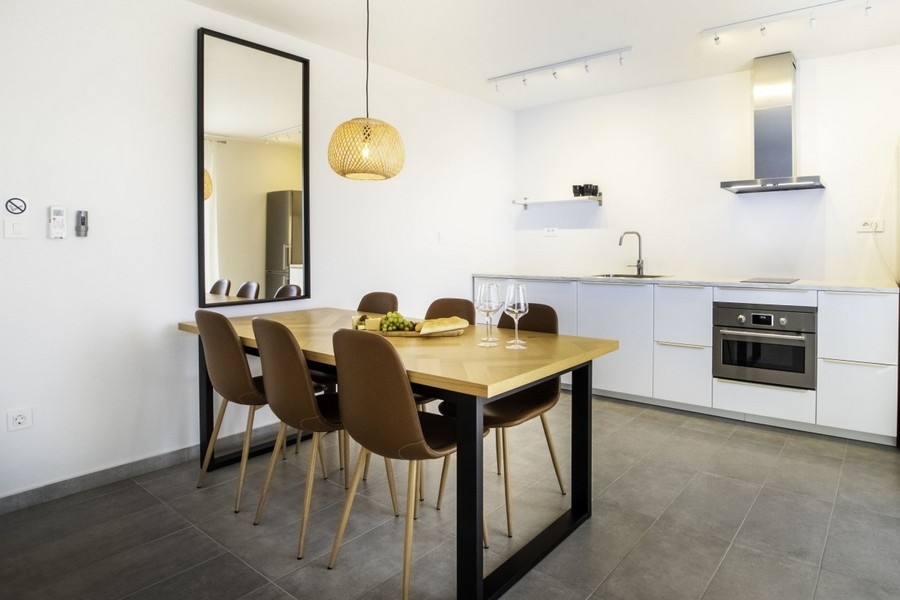 Otwarta kuchnia ze stołem jadalnym i nowocześnie wyposażoną kuchnią