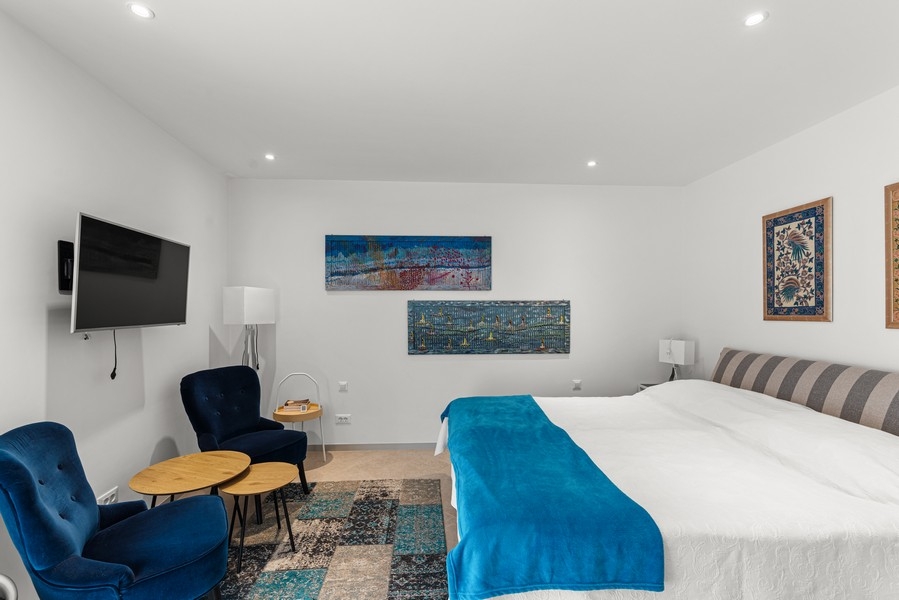 Sypialnia z dużym podwójnym łóżkiem i częścią wypoczynkową