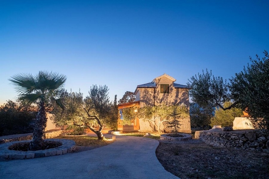 Dom dalmatyński w wieczornej atmosferze z oświetlonym ogrodem