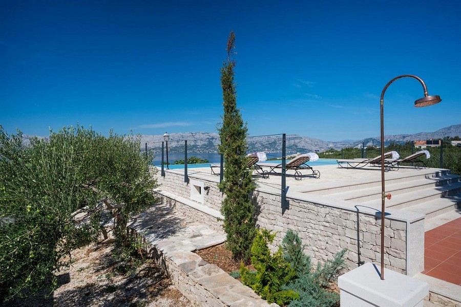 Taras z basenem bez krawędzi i panoramicznym widokiem na morze i wybrzeże