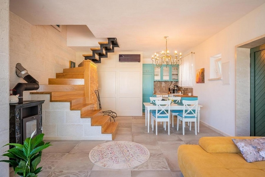 Część dzienna z otwartą kuchnią i schodami w stylu dalmatyńskim