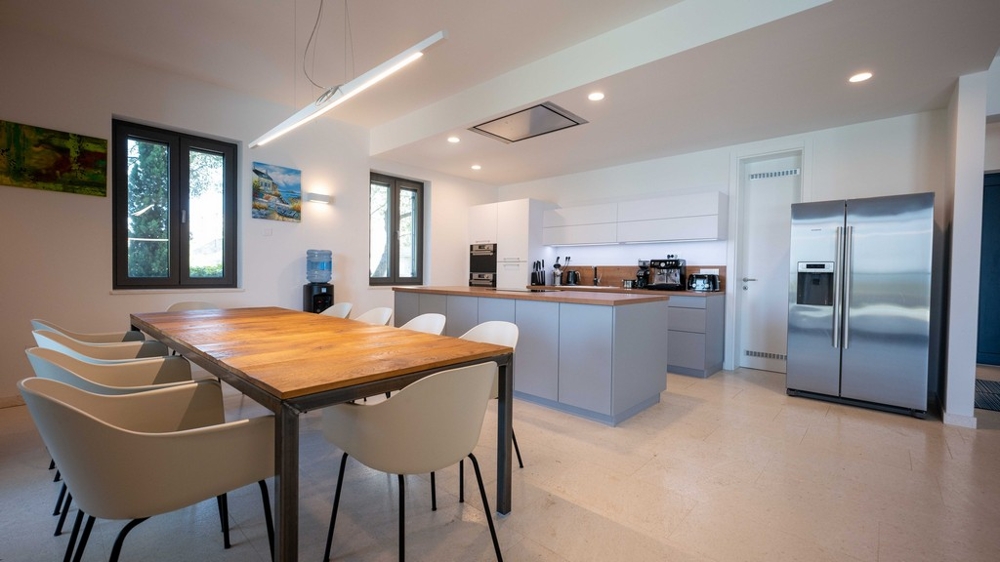 Nowoczesna kuchnia z wyspą kuchenną i dużym stołem jadalnym