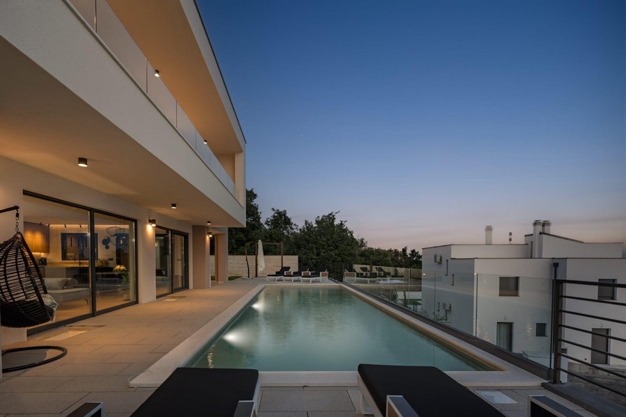 Nowoczesna willa z basenem bez krawędzi i widokiem na morze wieczorem