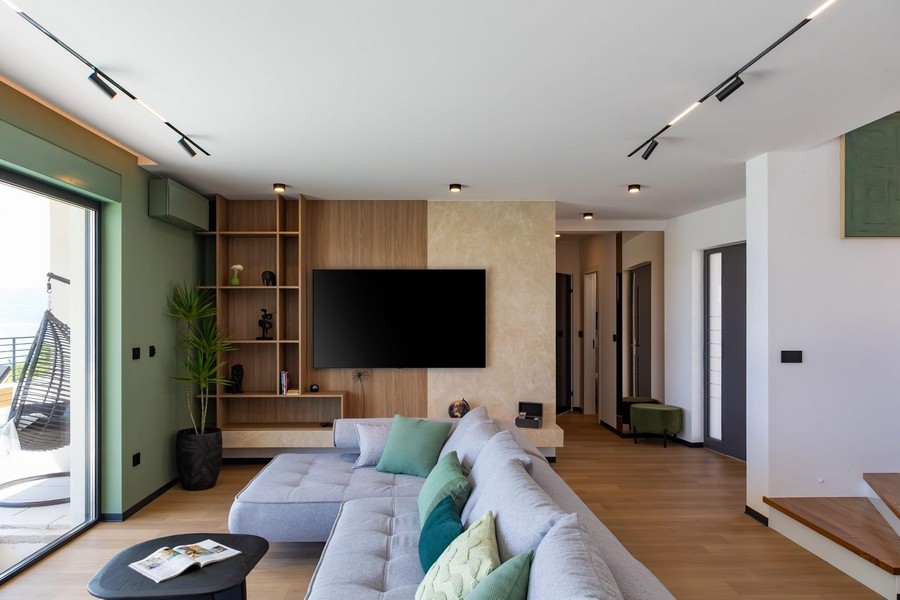 Otwarta część dzienna ze ścianą telewizyjną i designerskimi schodami