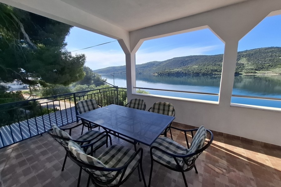 Zadaszony teren zewnętrzny ze stołem jadalnym i widokiem na morze