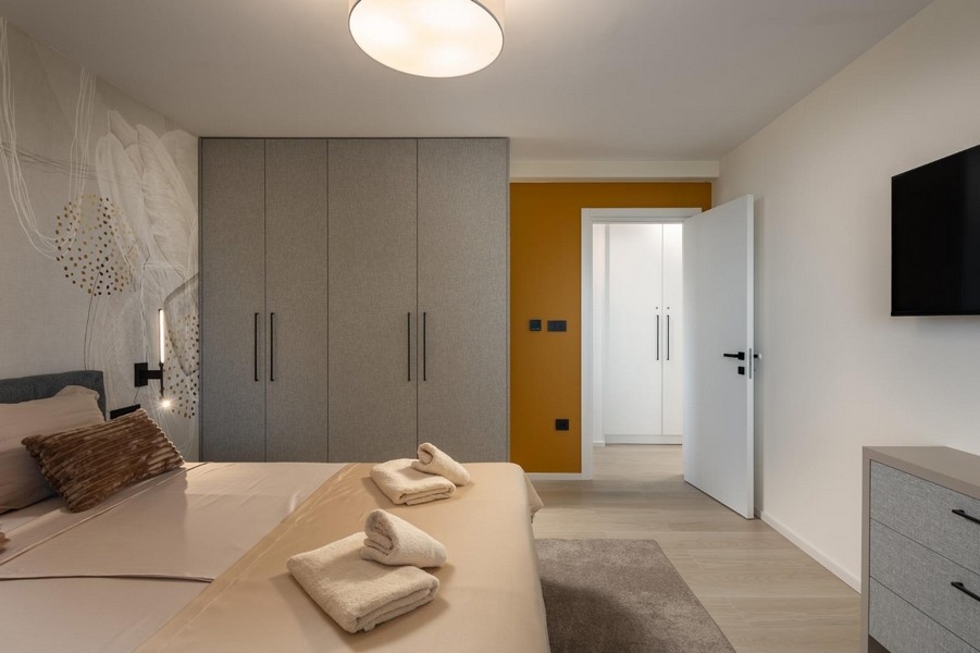 Jasna sypialnia z wbudowaną szafą i nowoczesnymi elementami