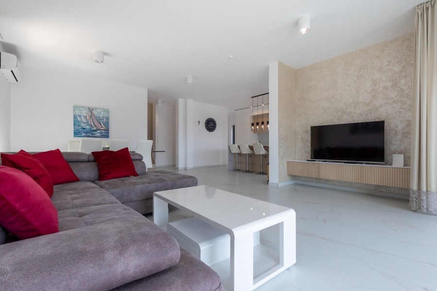 Przestronny salon z sofą i miejscem na telewizor