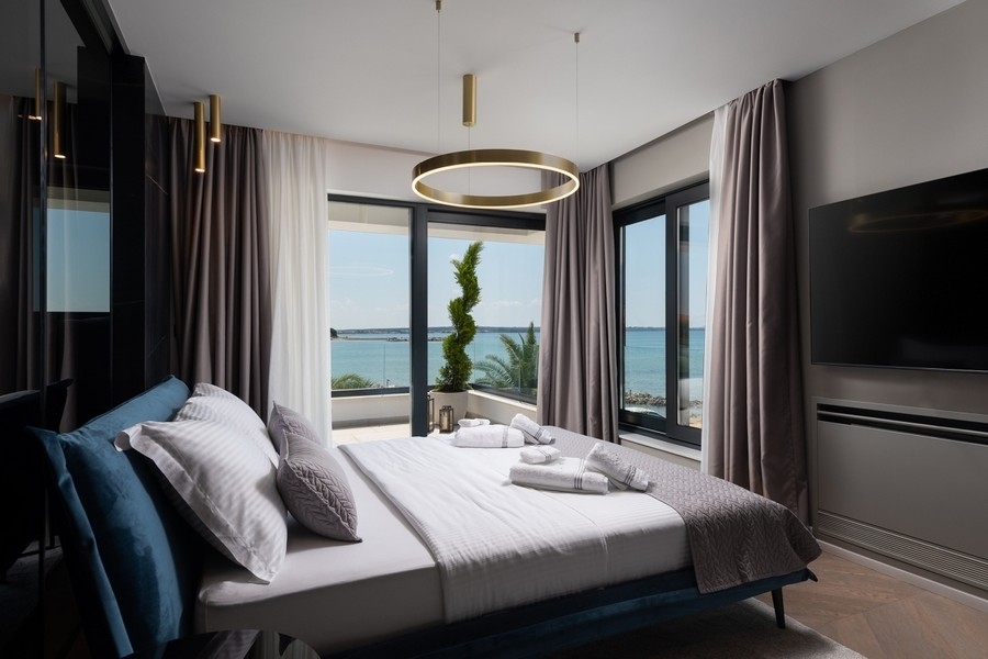 Sypialnia z dużymi oknami i widokiem na morze w Chorwacji