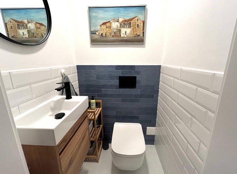 Oddzielna toaleta z umywalką i płytkami ściennymi