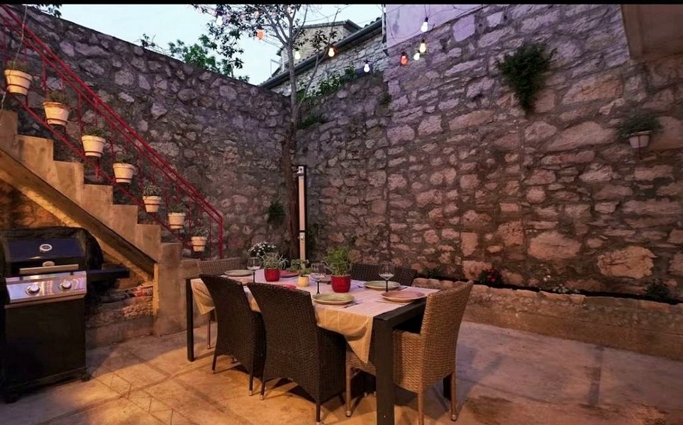 Wewnętrzny dziedziniec ze ścianą z kamienia naturalnego i częścią wypoczynkową na świeżym powietrzu