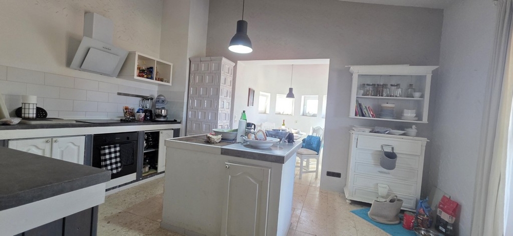 Kuchnia z wyspą kuchenną i przylegającym do niej salonem