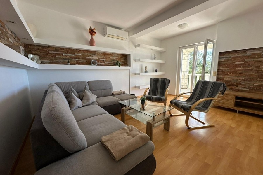 Pokój dzienny z sofą, fotelem i nowoczesnym projektem ściany