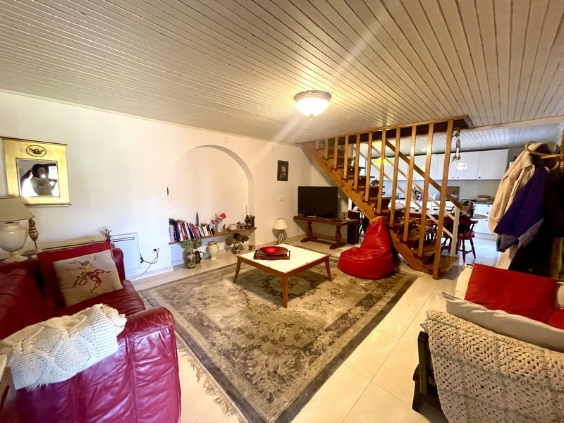 Pokój dzienny z sofą, dywanem i otwartymi schodami