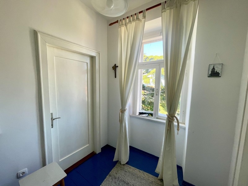 Jasny korytarz z oknem i widokiem na zieleń