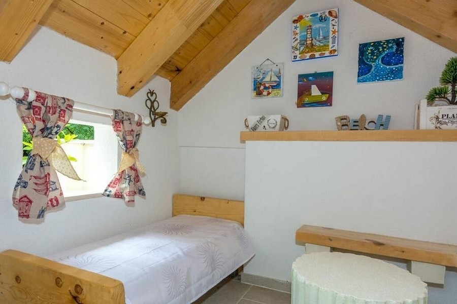 Część sypialna na poddaszu z drewnianymi belkami i przytulną atmosferą