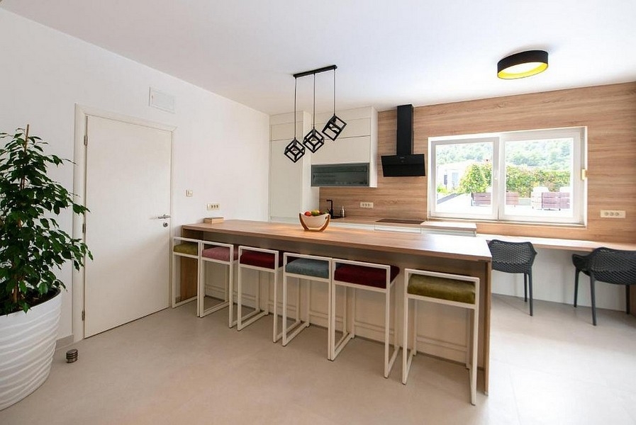 Otwarta kuchnia z wyspą i miejscami do siedzenia w nowoczesnym stylu