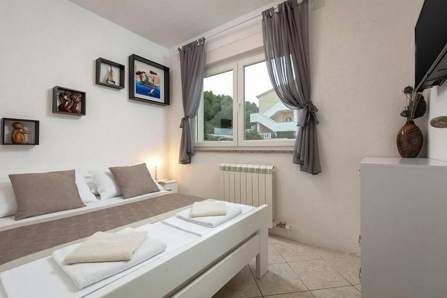 Sypialnia z łóżkiem małżeńskim i oknem z widokiem na zieleń