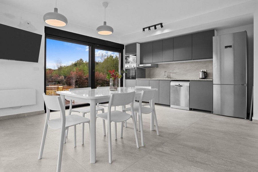 Nowoczesny salon i jadalnia z otwartą kuchnią i wyjściem na taras