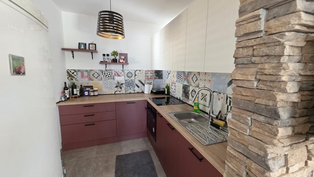 Kuchnia z nowocześnie wyposażoną kuchnią i tylnymi płytkami