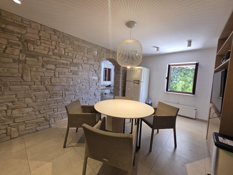 Kuchnia z kamienną ścianą i nowoczesną jadalnią